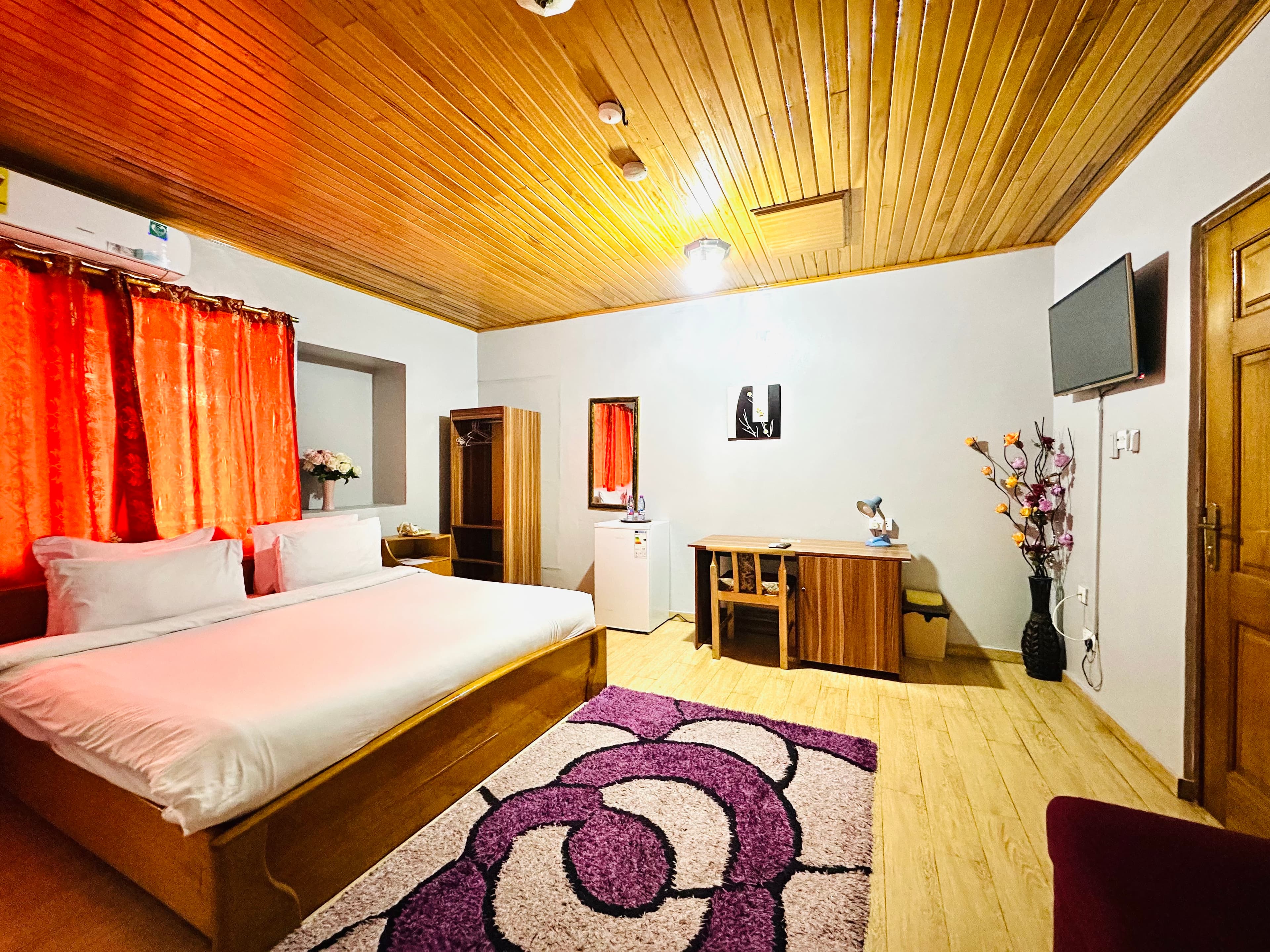 Queen Room with wood ceiling and orange curtains